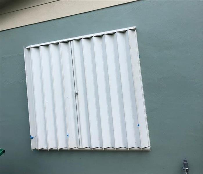 Metal accordion storm shutters closed to protect a home from the oncoming hurricane.